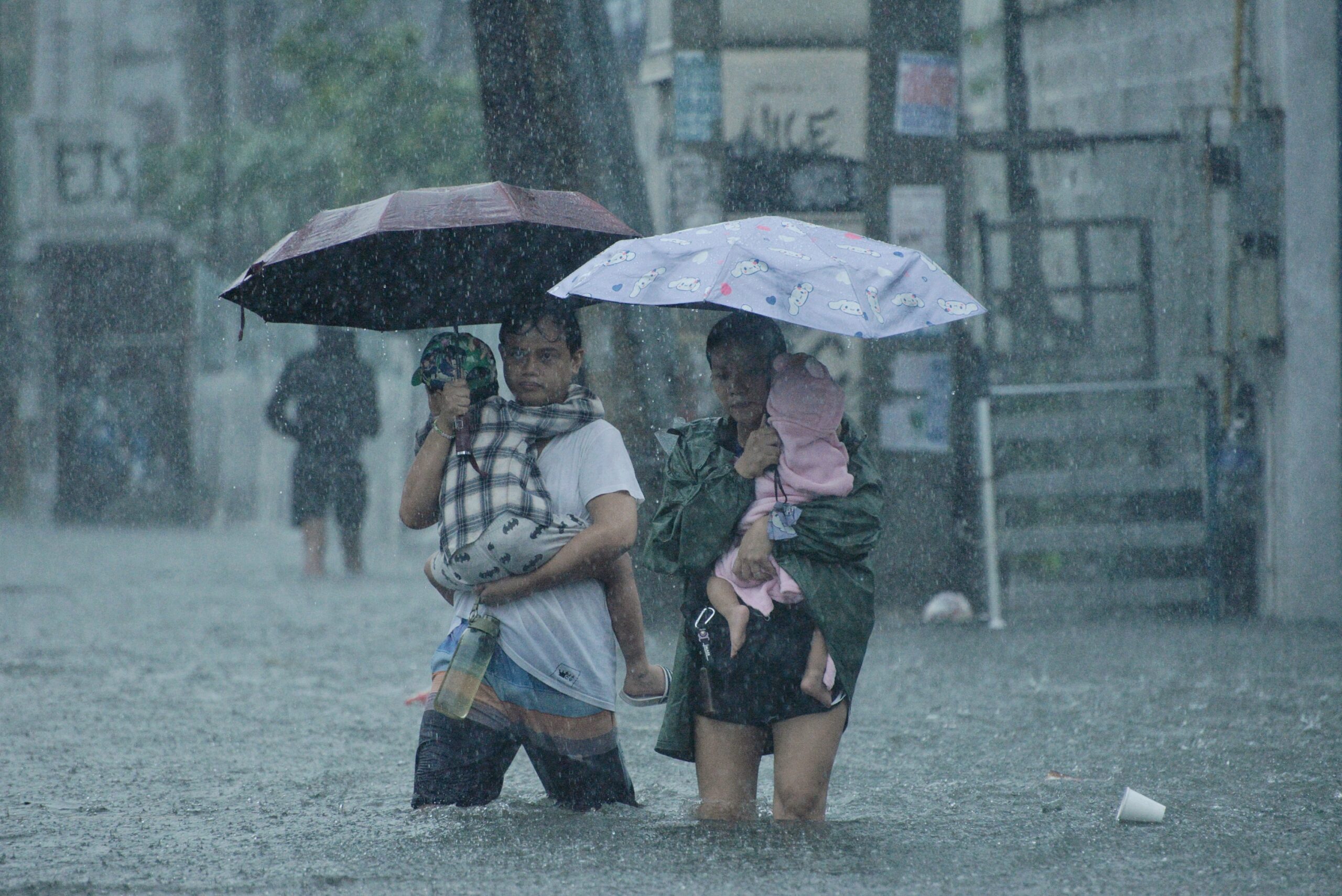 Flooded street in Quezon City, Philippines. The family left their home for safety as Typhoon Carina brought massive flooding on 24 July 2024. Copyright: UNICEF/UNI617017/Piojo